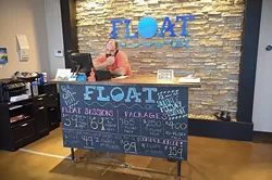 Matt Ligon, one of the owners of Float OKC, on the phone with customers at the front dest of the Edmond Business. mh