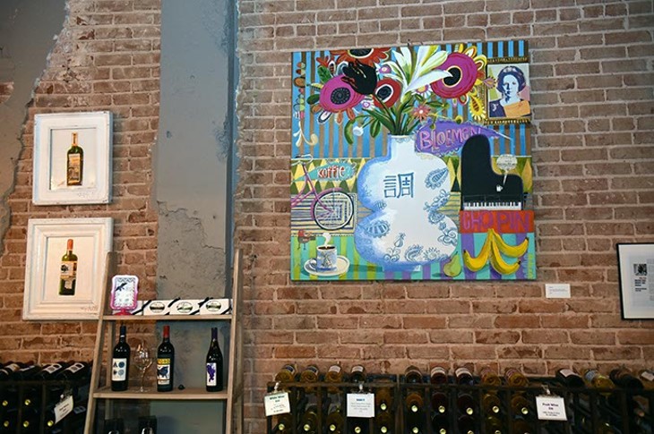 Artwork by Skip Hill above wine racks and other decor, at The Waters Edge Winery in Auto Alley.  mh