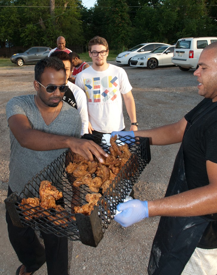 Sherron Bennett passes out free samples fresh out of the fryer to patrons waiting in line for Bobo's Chicken. (Mark Hancock)