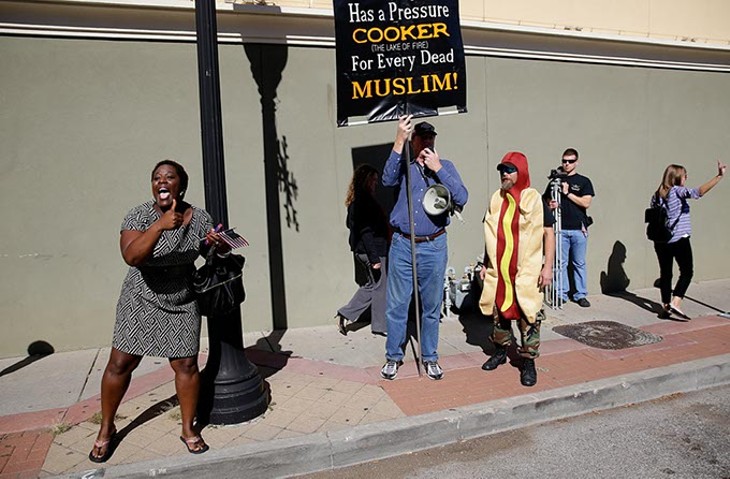 Kuma Roberts left shouts support to Muslims marching with the Oklahoma branch of the Council on American-Islamic Relations during the Tulsa Veterans Day Parade Nov. 11, 2015. At right Jim Gilles protests the inclusion of Muslims in the parade. (Photo Mike Simons / Tulsa World / File / Provided)