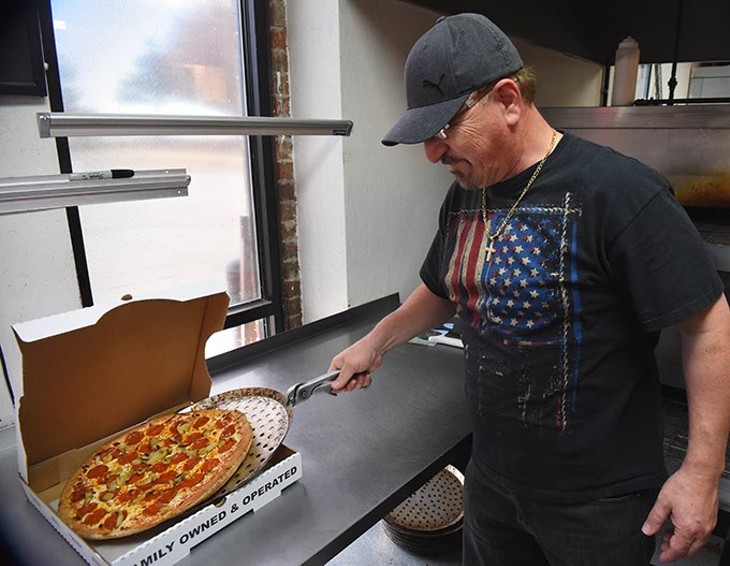 Frank Sweiss, owner of All American Pizza with eight metro locations, takes a fresh baked pepperoni and mushroom pizza out of the oven and into a box, at the 16726 N. Pennsylvania location, 12-8-15. - MARK HANCOCK