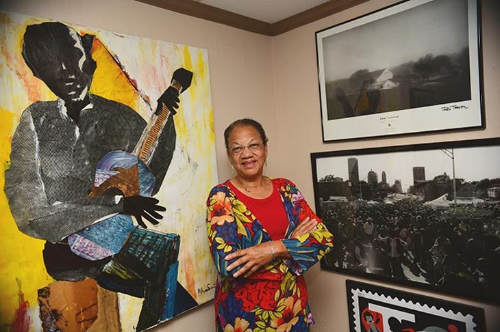 Anita Arnold, executive director of BLAC, with artwork in her office including a large work of Charlie Christian by artist Melvin R. Smith, a graduate of Fredrick A. Douglas High School like Charlie Christian.  mh
