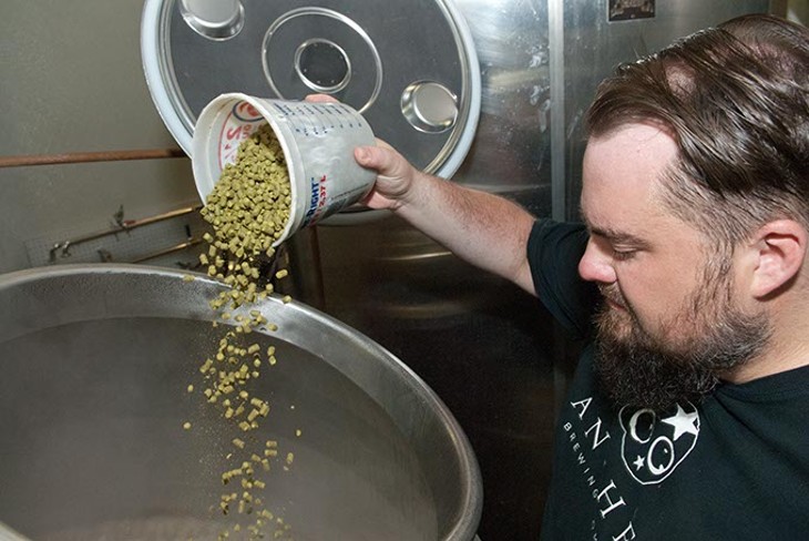Anthony pours hops into a brewing vat (Mark Hancock)
