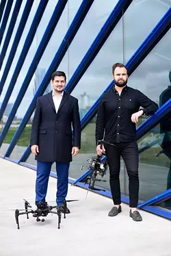 Ersin Demirci and Nick Brown pose for a photo with drones at the Boathouse District, Monday, April 11, 2016. - GARETT FISBECK