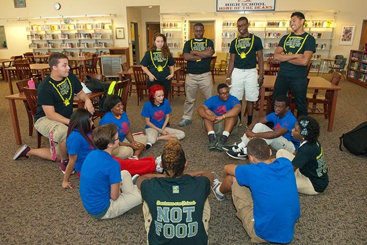 John Marshall High School Link Crew members with some of the freshmans they partner with, (blue shirts), in the library at the school showing how they first got together for orientation.  mh