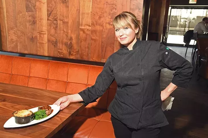 Chef Elizabeth Howe places her 8 oz filet with potatoes, sauteed broccolini, and bone-marrow demiglace, on a table at Flint. mh