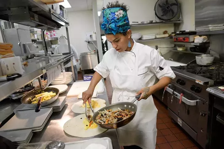 The Lobby Cafe & Bar breakfast chef Angela Renee Chase prepares sausage and egg breakfast burritos. | Photo Garett Fisbeck
