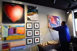 Brent Learned hands art for the Studio Gallery Spring Art Show, Tuesday, April 5, 2016. - GARETT FISBECK