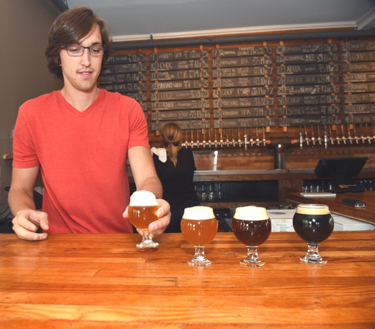 Bartender Chris Evans brings some tasters to the forfront prior to the start of a Roughtail Pint Night event, Thursday, 5-14-15.  mh