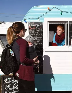 Customers Molly, left, and Samantha Cooper, order some hot chocolate at the Katiebut's camper, from Autumn Urton, left, and Jen Bellah, at the Holiday Pop-Up Shops in Midtown, 12-18-15, Oklahoma City. - MARK HANCOCK