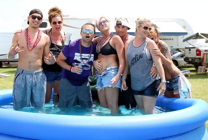 A group of campers from Oklahoma and Kansas pose in a blow-up pool in between their campsites at Rocklahoma in Pryor, Okla. on Saturday, May 27, 2017. (Cara Johnson).