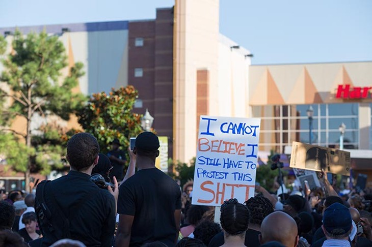 Protestors hold up signs at the Black Lives Matter protest on Sunday, July 10, 2016. - EMMY VERDIN