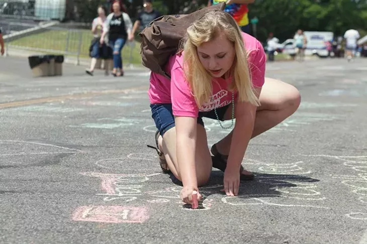 Planned Parenthood volunteer Bailey Ashbaker writes "I stand with Planned Parenthood" in chalk on 39th St. on Saturday, June 24, 2017. (Cara Johnson).