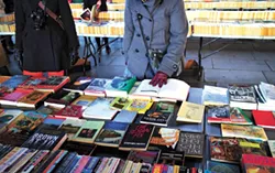 London, England - January 24, 2015: People browsing the books for sale at the Southbank Centre Book Market in London, England. Located beneath the Waterloo Bridge the market is open all year round. - BIGSTOCK