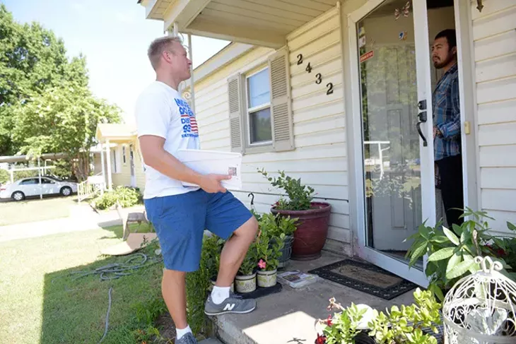 Mickey Dollens, a former U.S Grant High School teacher, talks with Isaias Perez in a neighborhood in District 93. (Garett Fisbeck / file)