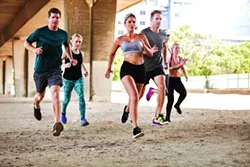 Determined group of young people running together in city. Running club members training together. - BIGSTOCK