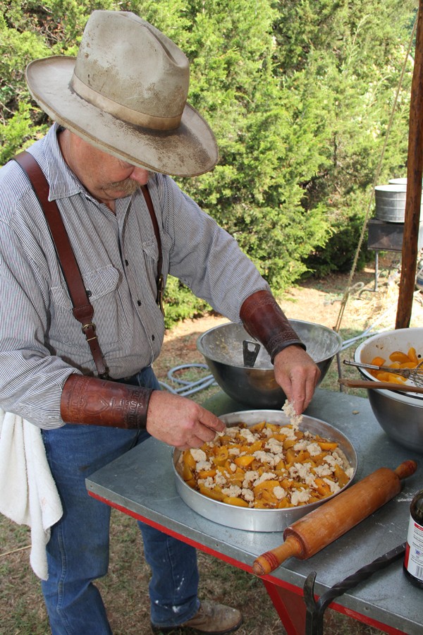 A chuck wagon cook prepares a peach cobbler. | Photo National Cowboy & Western Heritage Museum / provided