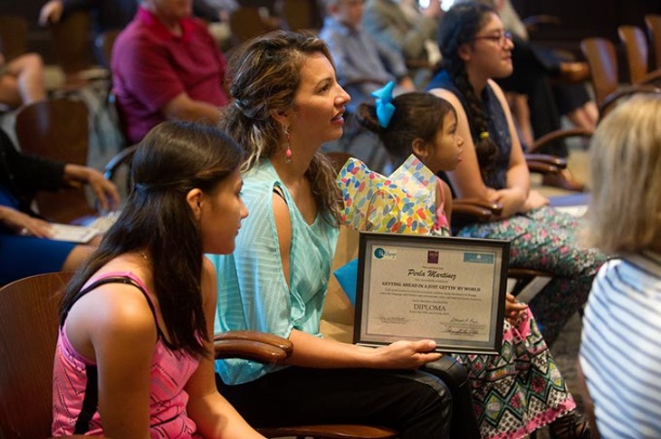 Perla Martinez sits with her family after receiving her diploma during a ReMerge graduation at the Oklahoma City Community Foundation, Thursday, June 30, 2016. - GARETT FISBECK