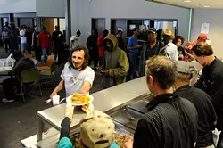 WestTown resource center and day shelter diners queue for a chef-prepared meal during a 2015 Turning the Tables on Hunger event. (Garett Fisbeck / file)