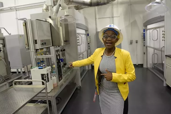 Lead lab engineer Paulina Mwangi talks - about the GE Global Research Oil and Gas - Technology Center laboratory during a recent tour. | Photo Garett Fisbeck