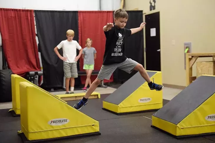 Gabe Conner, 9, runs a course as Jacob Wells, 11, and Cheyenne Conner, 11, look on during a class. (Photo Garett Fisbeck)