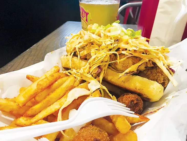 Fried oyster po’boy served with fries and hushpuppies - JACOB THREADGILL