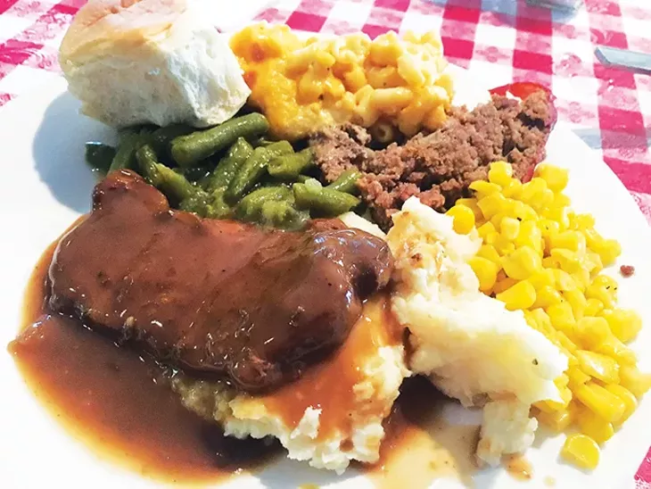 Smothered pork chop with mashed potatoes, meatloaf, - macaroni and cheese, green beans and corn - JACOB THREADGILL