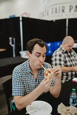 Oklahoma Gazette’s Jacob Threadgill samples the barbecue chicken bacon calzone from Rodney & Lisa Pizza at the Great TASTE of a Fair competition. - ALEXA ACE