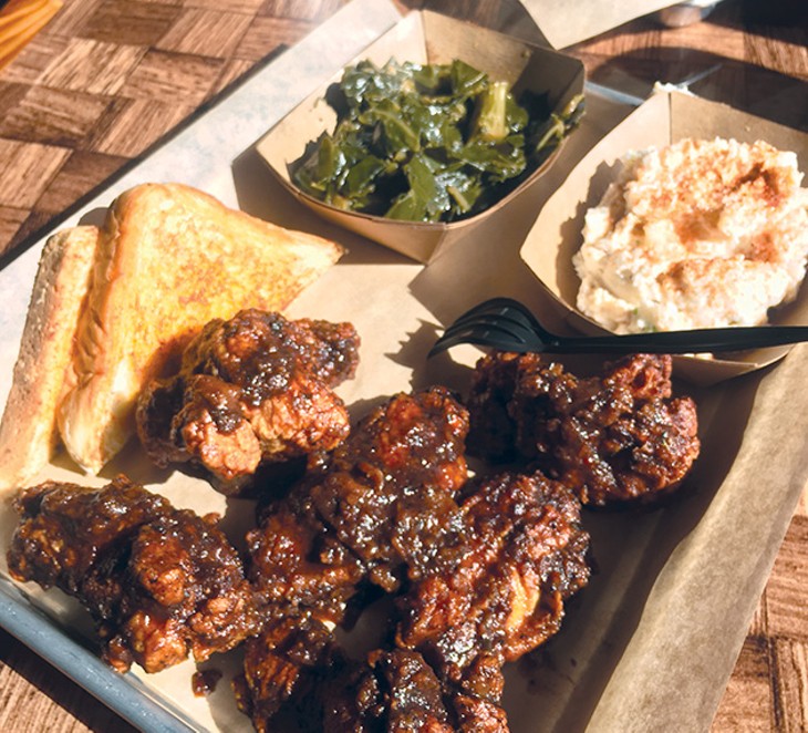 Fried chicken wings covered in jerk sauce with potato salad and greens at Cornish Smokehouse - JACOB THREADGILL