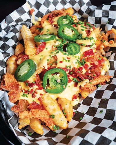 Mosh Pit Fries with liquid gold cheese sauce, bacon, jalapeños and crispy onions - PHILLIP DANNER