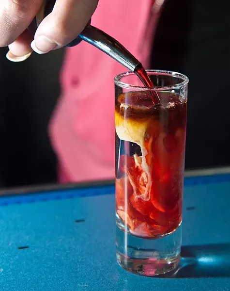 Sadie pours the last ingredient into a Zombie Brain shot, at W XYZ Bar inside the ALoft hotel. mh