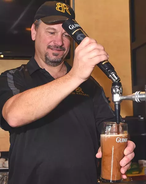Black Raven Pub co-owner, Bryan Newport, draws a Guiness at the Choctaw Irish pub. mh