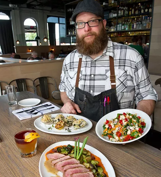 Exec. Chef Chris McKenna at Packard's presents a kale chopped salad with gorganzola bleu cheese, red onion, chick peas, peppidu peppers, and a golden basalmic dressing. On one plate is Rockinville Oysters behind the Autumn obile cocktail made with rye whiskey, Cinnamon Apple Shrub, Ango Bitters and Tawny Port float. For the main dish, Duck with bacon and brussels, butternut squash puree with hard cider dressing. (Shannon Cornman)
