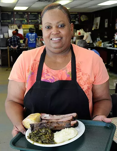 Owner Debra Ivory poses for a photo with Pork Rib Dinner at George's Happy Hog BBQ in Oklahoma City, Thursday, May 28, 2015. - GARETT FISBECK