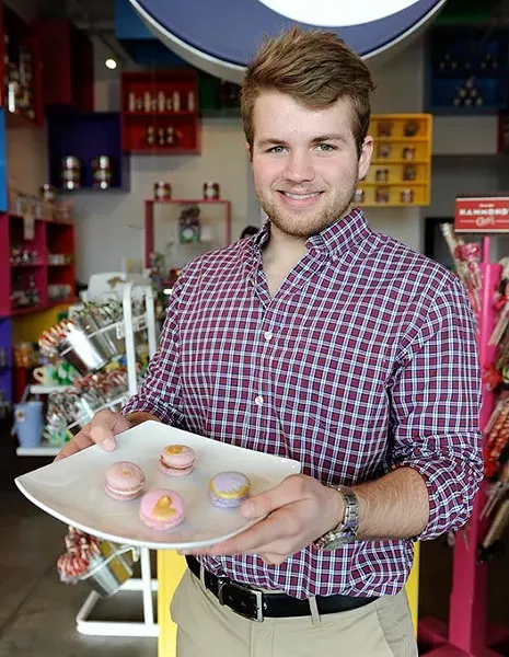 Carson Park holds a plate of macaroons (cinnamon, raspberry, hazelnut, blueberry) at Uptown Candy Co. in Oklahoma City, Wednesday, Jan. 28, 2015. - GARETT FISBECK