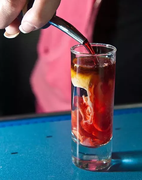 Sadie pours the last ingredient into a Zombie Brain shot, at W XYZ Bar inside the ALoft hotel. mh
