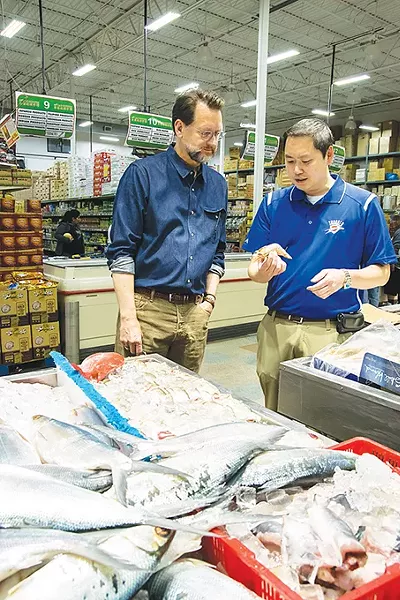 Ba Luong tells chef Kurt Fleischfresser about the latest shipment of tiger prawns. - MARK HANCOCK