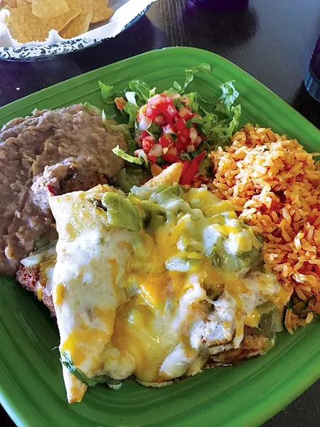 Sopapillas stuffed with carne adovada and topped with queso and green chile sauce - JACOB THREADGILL