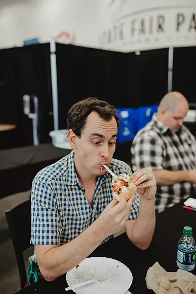 Oklahoma Gazette’s Jacob Threadgill samples the barbecue chicken bacon calzone from Rodney & Lisa Pizza at the Great TASTE of a Fair competition. - ALEXA ACE