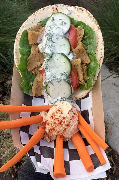A seitan-based gyro served with tzatziki sauce and a side of hummus - JACOB THREADGILL