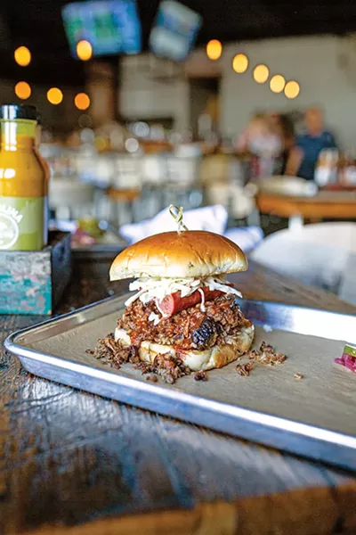 The Full Boar sandwich is piled high with pulled pork, brisket, a hot link and coleslaw. - ALEXA ACE
