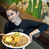Server Dulce Robles with a dish of Parrilla chicken topped with plenty of sauteed onions, at Alfredo's Mexican Cafe in Moore.  mh