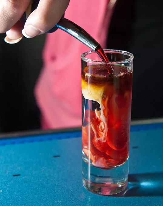 Sadie pours the last ingredient into a Zombie Brain shot, at W XYZ Bar inside the ALoft hotel. mh
