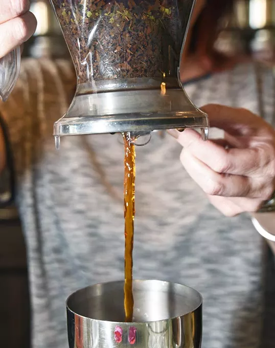 Kristy Jennings, owner of t an Urban Teahouse, pours the hot tea into the first cooling container filled with Ice. mh