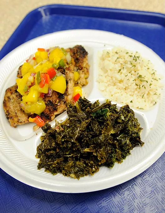 Jerk chicken with mango salsa, island rice (coconut lime infused), callaloo (kale), at The Islands in Oklahoma City, Friday, June 5, 2015. (Garett FIsbeck