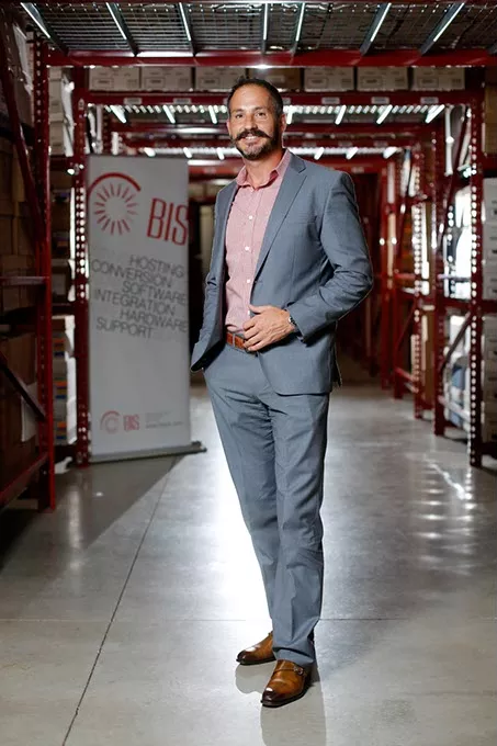Danny Rotelli, owner of Business Imaging Solutions, poses for a photo in the warehouse of his business in Edmond, Tuesday, July 28, 2015. - GARETT FISBECK