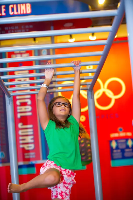Skylar Lawrence works her way across the horizontal ladder at the fairly new Power Play exhibit at Science Museum of Oklahoma. - SHANNON CORNMAN
