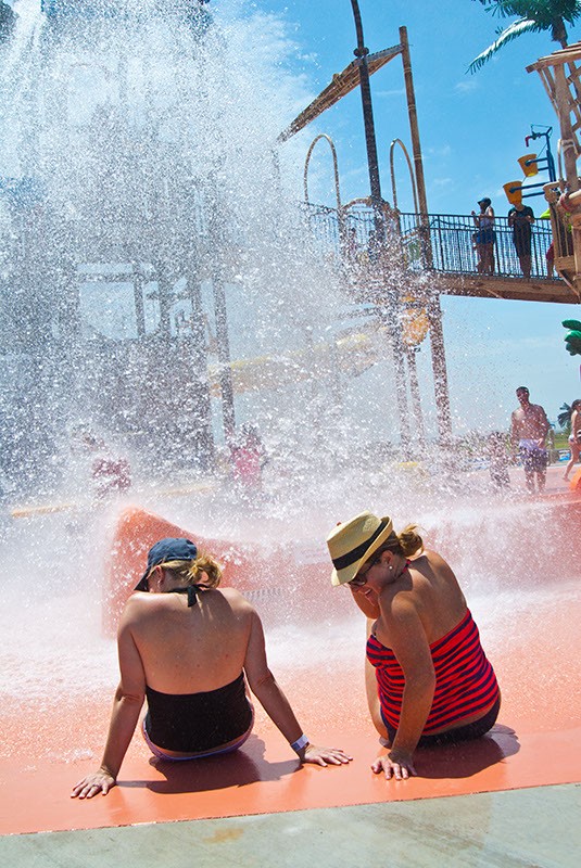 Women get wet with a giant spray of water that goes off every 3 minutes at Andy Alligator's water park recently.