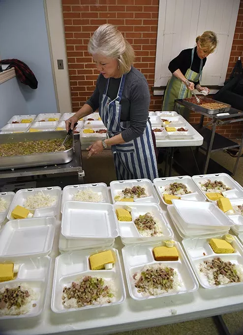 From left, Barbara Hill and Alison Calhoon, volunteers with Westminster Presbyterian Church in Crown Heights, dole out portions of "Hoppin Johns", cornbread, and cherry crisp dessert, for the Mobile Meals program being delivered shortly after it's ready, to neady recepients on New Years Eve, 12-31-15, in OKC. - MARK HANCOCK