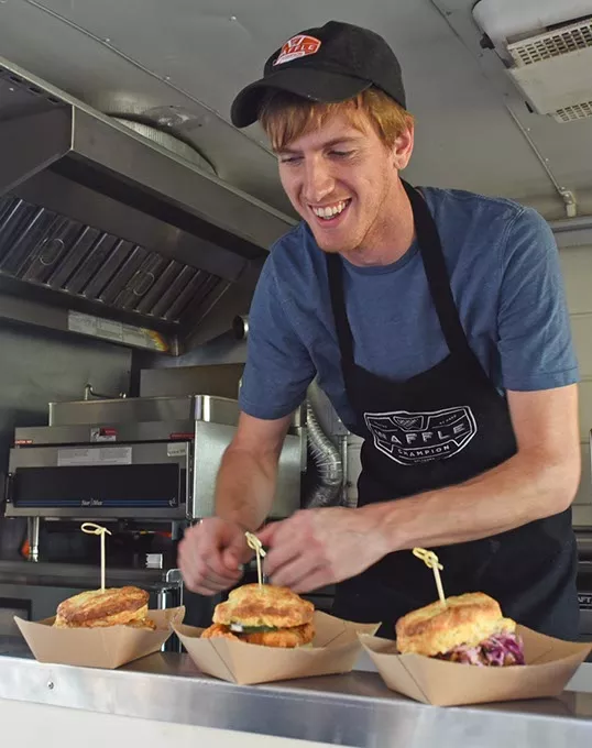Peter O'Neal, Buttermilk Southern Sliders food truck manager, lines up their 4 sliders in the order window of the food truck. mh